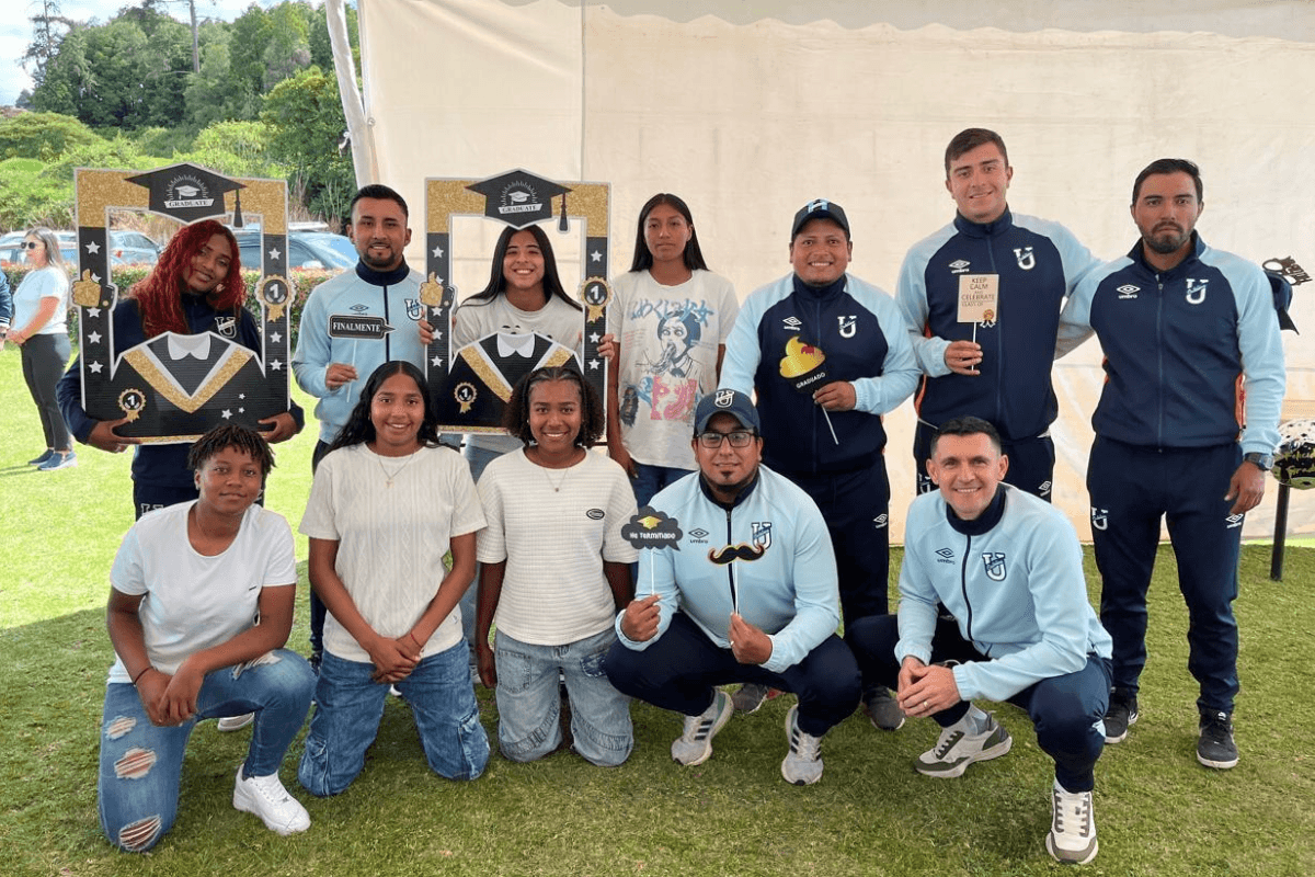 Estudiantes-atletas y personal de Comuna Habitabilidad en un evento de graduación al aire libre